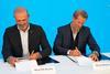 The image shows Neal de Roche, president of Wilhelmsen Port Services(left) and Bruce Brown , director of C-Zero Maritime (right), signing the agreement