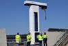 onshore power connection at the Port of Kapellskär in Stockholm with four workers in hi-viz standing at its base