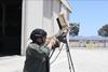 Man with rifle pointing it at the sky looking for pretend drones
