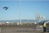 The picture shows a drone being flown by an operator at the Port of Tarragona