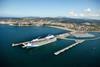 A cruise ship docks at the Port of Bilbao, Spain with mountains in the background