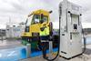 The image shows a Hyster hydrogen fuel cell-powered terminal tractor in action at HHLA