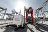 The image shows a Kalmar electric straddle and charging infrastructure