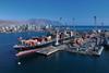 Iquique Terminal Internacional in Chile. Image shows a container ship at port with the city and low mountains behind