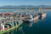 Three container ships at dock in Deltaport, Canada with cranes shoreside