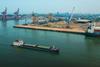 The image shows an overhead shot of a ship entering JSW Mangalore Container Terminal Pvt. Ltd
