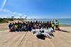 The image shows Port of Oakland volunteers, community partners, families and friends unite to clean up the local shoreline