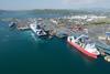 The image shows a wide angle shot of Larne Harbour with a ferry and workboat in the foreground