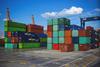 An image of colourful shipping containers stacked on a quayside
