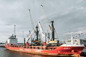 Liebherr ship-to-shore crane by a small container ship dockside