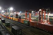 Containers being transported by rail at a port at night time