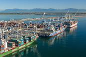 Three container ships at dock in Deltaport, Canada with cranes shoreside