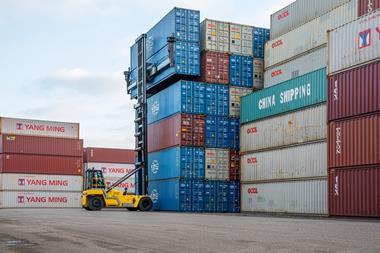 The image shows a Hyster electric container handler stacking boxes