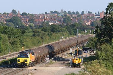 Colas Rail Freight Class 70 811 on a rail track with roofs in the distance