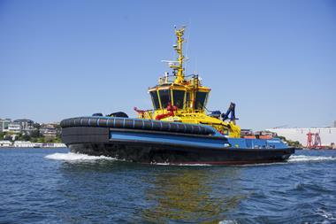 The picture shows a SAAM electric tug on the water