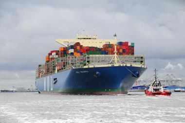 A bulk cargo carrier being pulled by a tugboat.