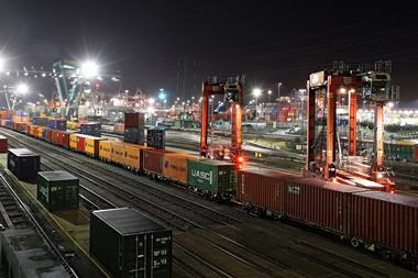 Containers being transported by rail at a port at night time