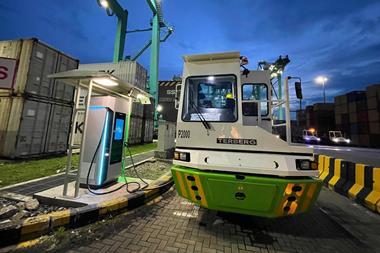 The image shows the electric prime mover fleet on the quayside at the Port of Tanjung Pelepas