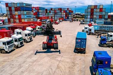 Containers and a forklift and trucks at a BMS terminal in Nigeria
