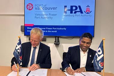 The image shows port execs from both ports signing the MoU