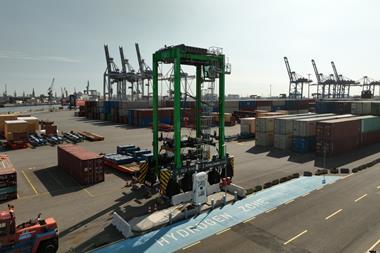 The hydrogen straddle carrier pictured on the quayside at Container Terminal Tollerort