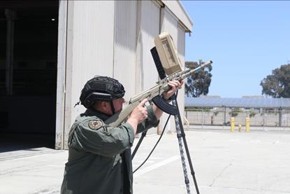 Man with rifle pointing it at the sky looking for pretend drones