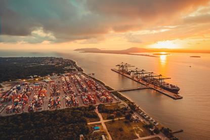 The photo shows a sunset drenched overhead shot of Porto Itapoá in Brazil