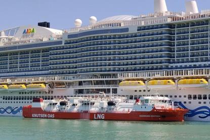 The Haugesund Knutsen LNG barge alongside a cruise ship at the Port of Barcelona
