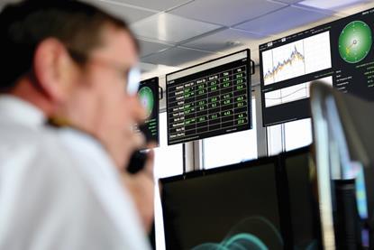 The image shows an operator in front of computer screens displaying OceanWise’s Port-Log Forecast Extension in action