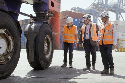 The image shows a Continental tyre being examined by operators on the quayside