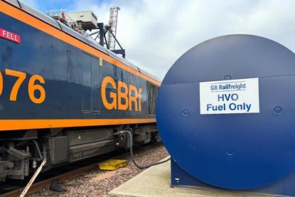 The image shows a GB Railfreight train with HVO storage in the foreground