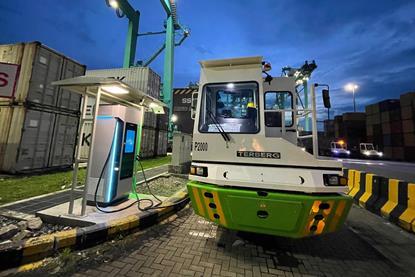 The image shows the electric prime mover fleet on the quayside at the Port of Tanjung Pelepas