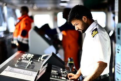 A ship's officer looks at bridge equipment