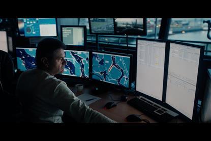 The photo shows an operator in front of the port security platform suite of monitors