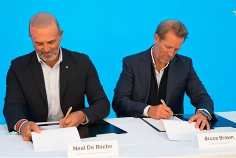 The image shows Neal de Roche, president of Wilhelmsen Port Services(left) and Bruce Brown , director of C-Zero Maritime (right), signing the agreement