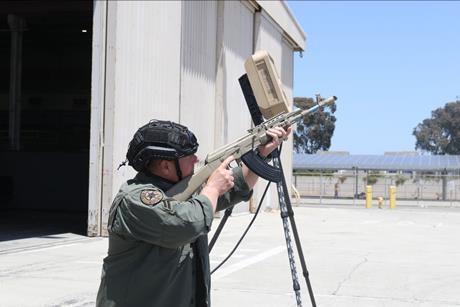Man with rifle pointing it at the sky looking for pretend drones