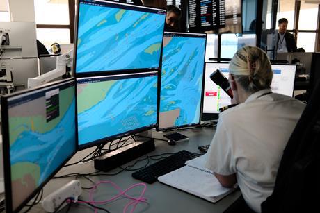 The image shows an operator seated in front of the Kongsberg Maritime VTS