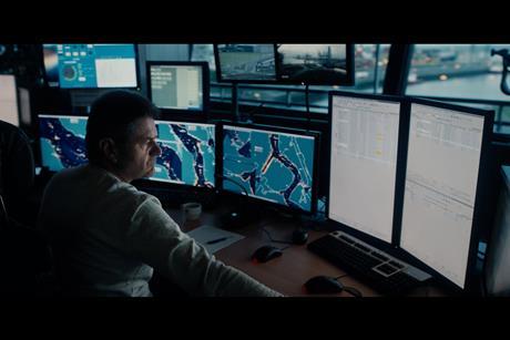 The photo shows an operator in front of the port security platform suite of monitors