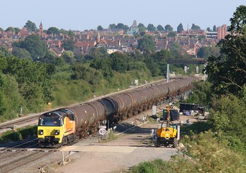 Colas Rail Freight Class 70 811 on a rail track with roofs in the distance