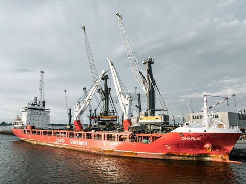 Liebherr ship-to-shore crane by a small container ship dockside