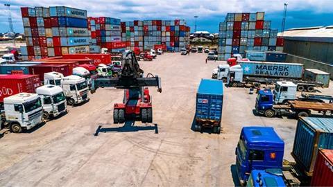 Containers and a forklift and trucks at a BMS terminal in Nigeria