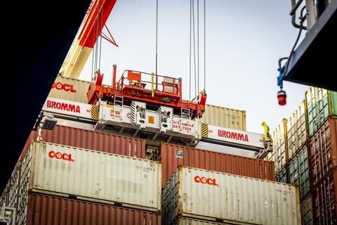 The image shows a Bromma electric STS spreader in action on the quayside